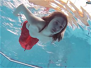 red clad teenage swimming with her eyes opened